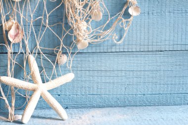 Starfish and fishing net on blue boards abstract vacation concept