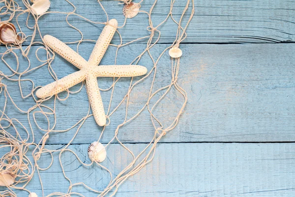 Starfish and fishing net on blue boards abstract vacation concept — Stock fotografie