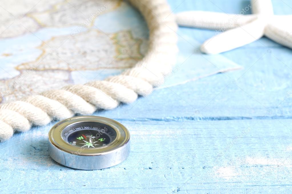 Compass and rope on blue boards travel concept