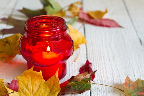 Vela de linterna roja con hojas de otoño en pizarras blancas —  Fotos de Stock