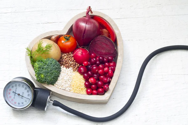 Comida saludable en el corazón y reducción del concepto de signos de presión — Foto de Stock