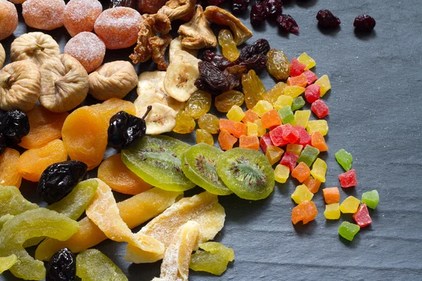 Конфеты сушеные смешанный ассортимент экзотических фруктов на черном мраморе — стоковое фото