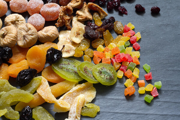 Candied dried mixed assortment of exotic fruits on black marble