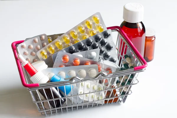 Cesta llena de pastillas y medicinas sobre fondo blanco — Foto de Stock