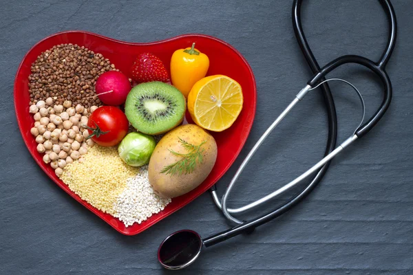 Healthy food on red heart plate cholesterol diet concept — Stock Photo, Image