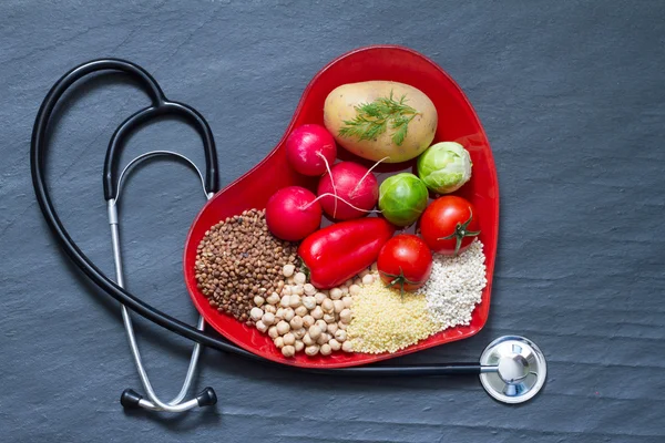 Healthy food on red heart plate cholesterol diet concept — Stock Photo, Image