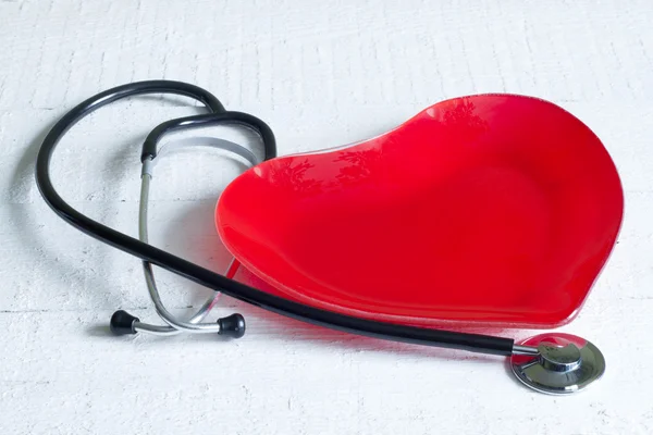 Stethoscoop en een rood hart plaat dieet concept op witte boards — Stockfoto