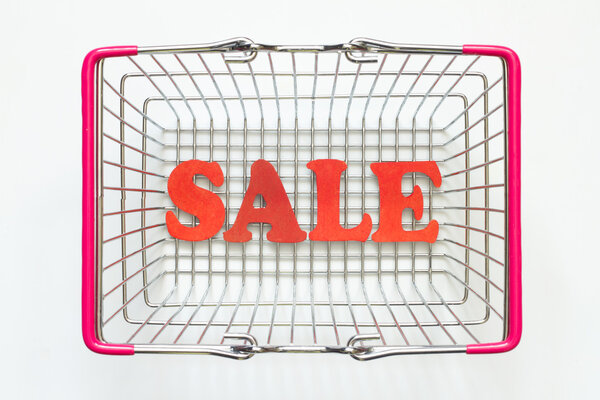 Продажа красных букв и корзина для покупок на белом фоне
