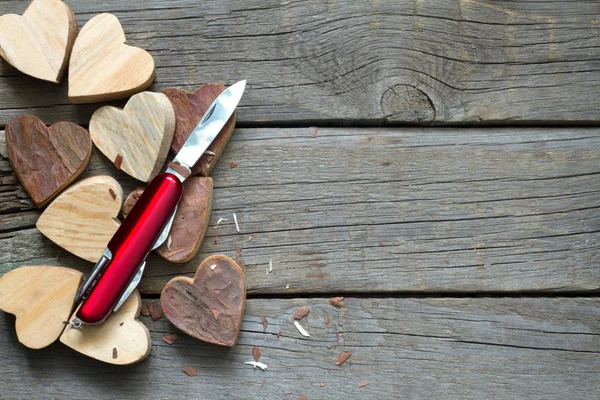 Cuori in legno intagliato e coltello astratto d'amore — Foto Stock