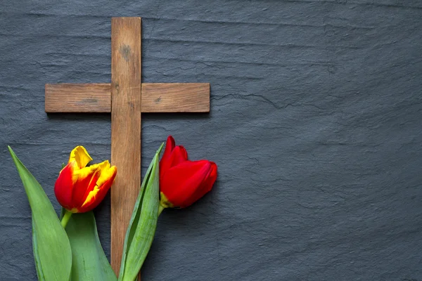 Abstract easter tulips and wooden cross on black marble — Stock Photo, Image