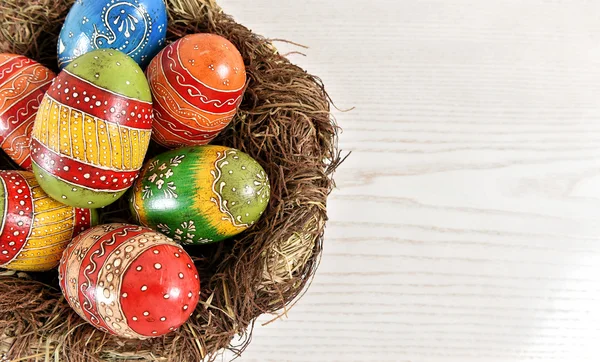 Colorful easter eggs in nest decoration — Stock Photo, Image