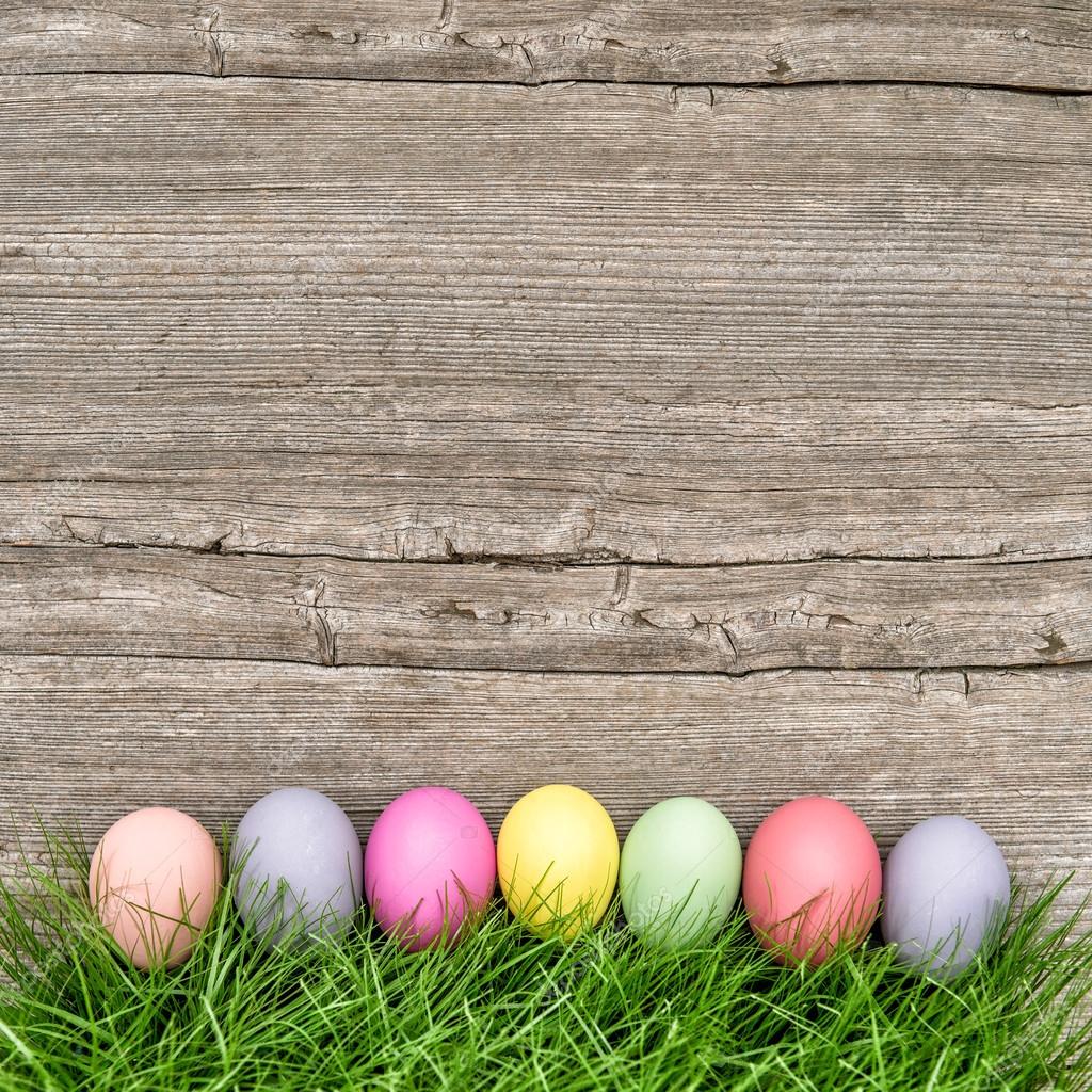 Ostereier im grünen Gras auf Holzgrund — Stockfoto © LiliGraphie #101575766