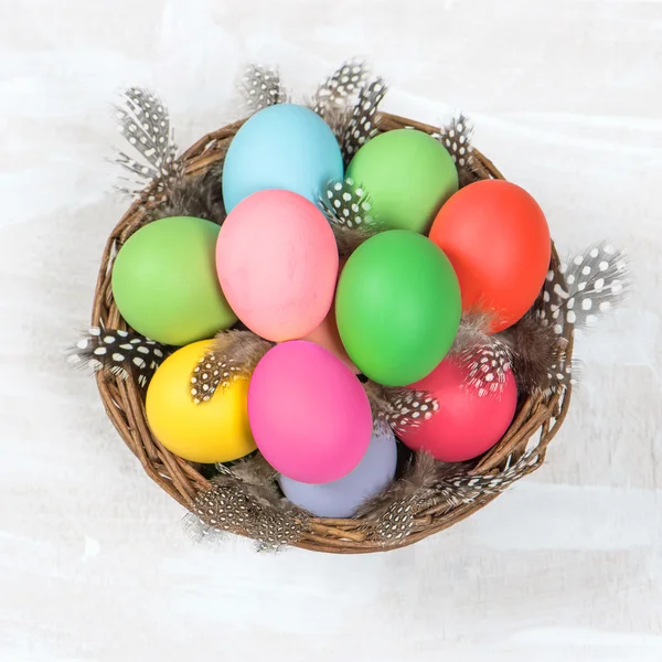 Huevos de Pascua en cesta sobre fondo de madera brillante — Foto de Stock