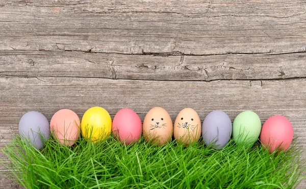 Ovos de páscoa coloridos em grama verde. Decoração engraçada — Fotografia de Stock