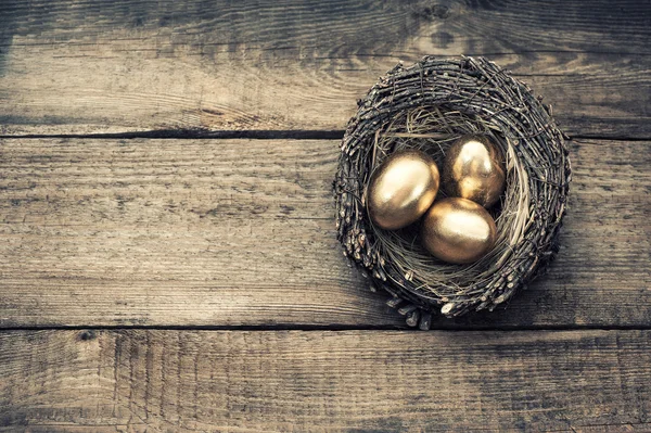 Золотые пасхальные яйца в гнезде птиц — стоковое фото