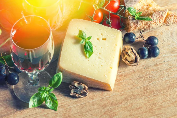 Cheese, red wine, walnuts, and tomatoes — Stock Photo, Image