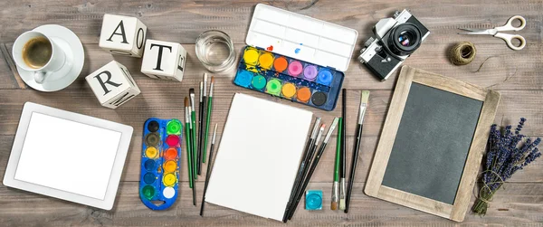 Artistic workplace. Watercolor brushes digital tablet camera — Stock Photo, Image