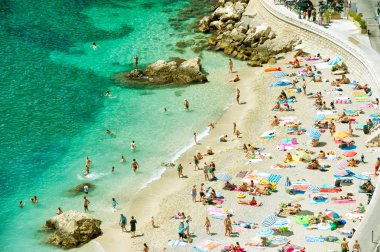 turistler, şezlong ve şemsiye ile plaj