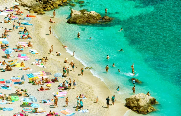 Beach with undefined people and kids. Mediterranean sea — Stock Photo, Image