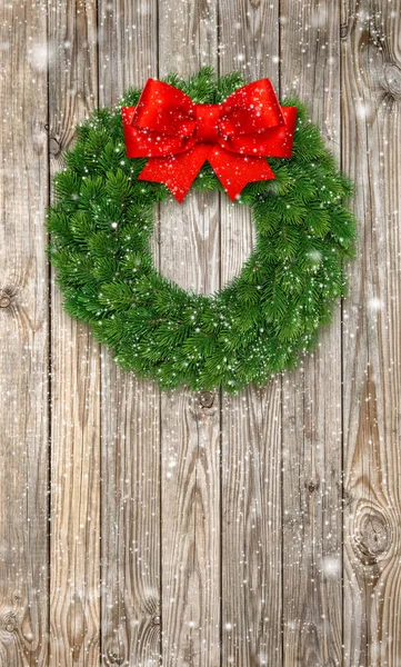 Christmas wreath with red ribbon bow with falling snow effect