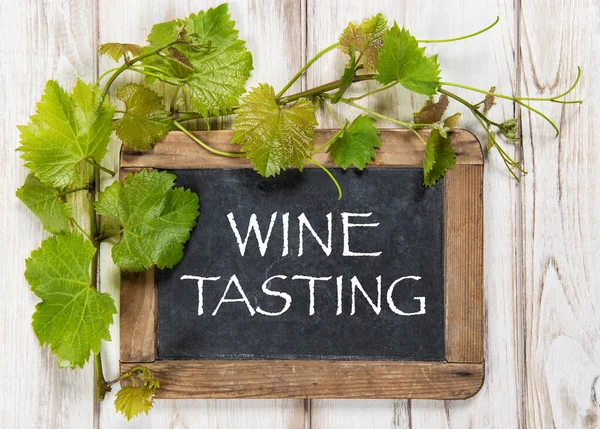 ワインの試飲 緑のブドウの葉の装飾と黒板 — ストック写真