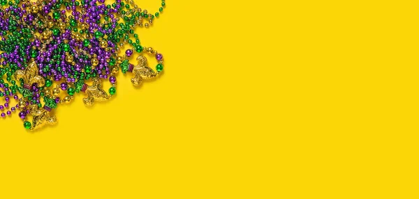 Carnival decoration template banner. Mardi gras beads on yellow background