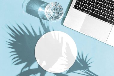 Laptop ve güneş gölgeli yuvarlak fare altlığı. İşyeri düzlüğü. Tasarımınız için fare altlığı modeli