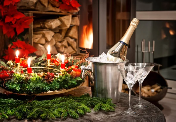 Decoração de Natal. garrafa de champanhe, copos e lareira — Fotografia de Stock