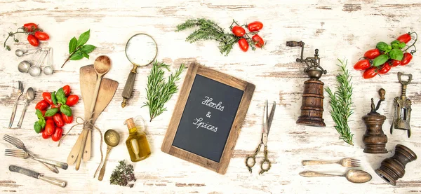 Vintage kitchen utensils with red tomatoes and herbs — Stock Photo, Image