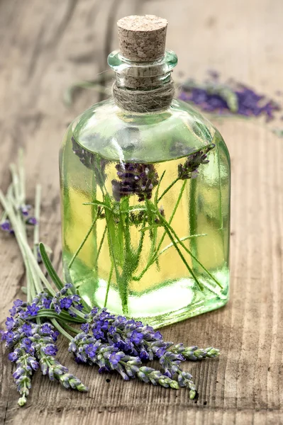 Botella de aceite de lavanda con flores frescas. hierbas saludables —  Fotos de Stock