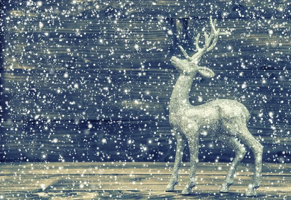 Christmas rådjur. Retrostil tonas bild med fallande snö — Stockfoto