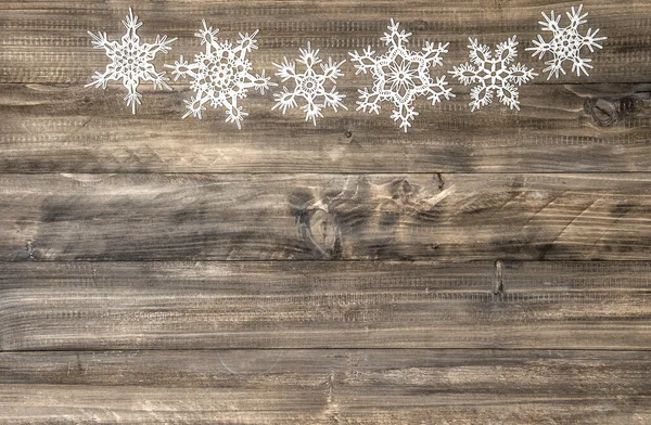 Adorno de Navidad copos de nieve blancos sobre fondo de madera — Foto de Stock