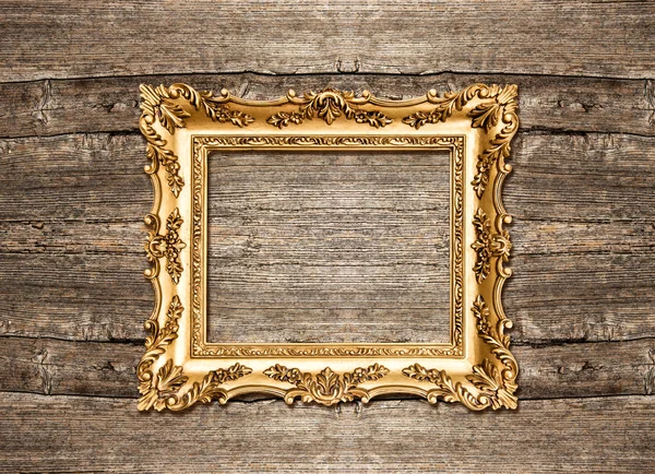 Antique golden frame over rustic wooden background — Stock Photo, Image