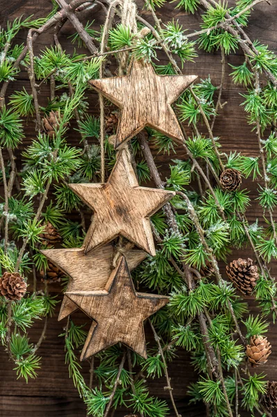 Χριστούγεννα διακοσμήσεις ξύλινα αστέρια και κλαδιά δέντρων πεύκων — Φωτογραφία Αρχείου