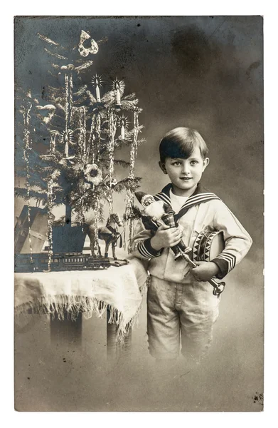 快乐的男孩用圣诞树、 礼物和老式玩具。古色古香的 p — 图库照片