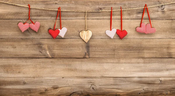 Hearts hanging on wooden background. — Stock Photo, Image