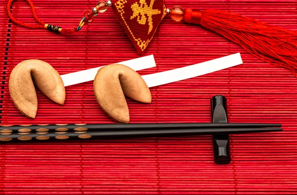 Китайский новый год талисман, печенье с предсказаниями и черные палочки для еды — стоковое фото