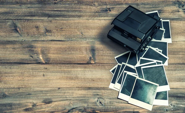 Old photo frames and camera on rustic wooden background — Stock Photo, Image