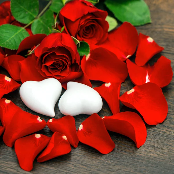 Κόκκινα τριαντάφυλλα και δύο καρδιές. Ημέρα του Αγίου Βαλεντίνου ή γάμου — Φωτογραφία Αρχείου