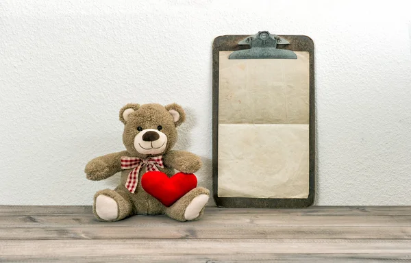 Медвежонок Тедди с красным сердцем и планшетом. День святого Валентина — стоковое фото