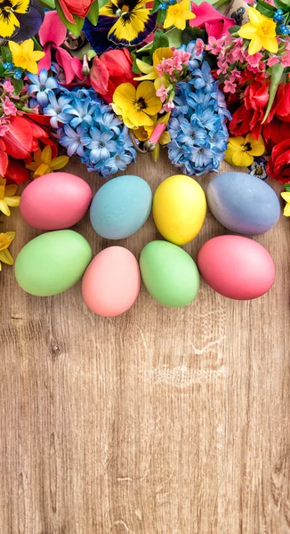 Lente bloemen en gekleurde eieren. — Stockfoto
