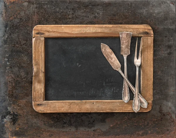 Chalkboard vintage e talheres de prata no fundo de metal enferrujado — Fotografia de Stock