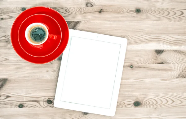 Digitales Tablet und rote Tasse Kaffee auf Holztisch. Jahrgangsst — Stockfoto