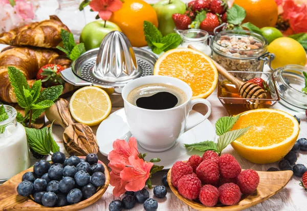 Kaffee, Croissants, Müsli, Honig, frische Beeren, Früchte. heilen — Stockfoto