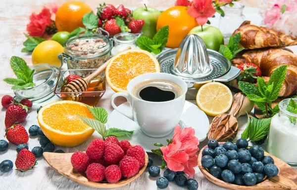 Coffee, croissants, granola, honey, fresh berries, fruits, flowe — Stockfoto