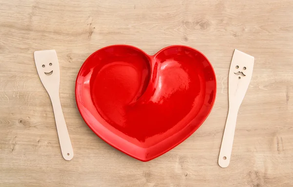 Wooden kitchen utensils and red tablecloth. Funny tools — Stock Photo, Image