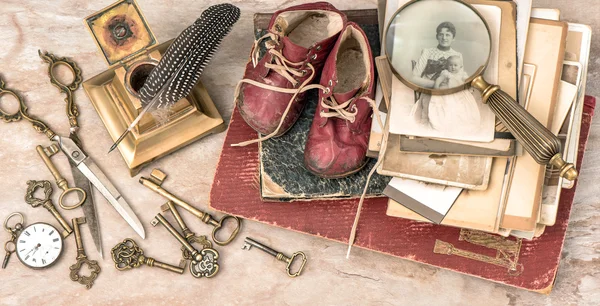 古色古香的书和照片，钥匙，婴儿鞋和写作配件 — 图库照片