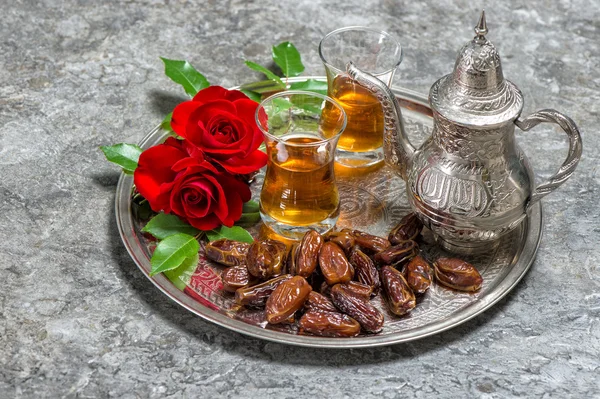 Tea, dates fruits and red rose flowers. Islamic holidays decorat — Stock Photo, Image