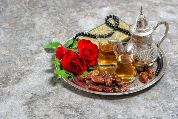 Tee, Dattelfrüchte, rote Rose, heiliges Buch quran und Rosenkranz. — Stockfoto