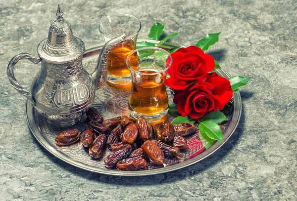 Chá, tâmaras frutas e flores vermelhas rosa. Hospitalidade oriental con — Fotografia de Stock
